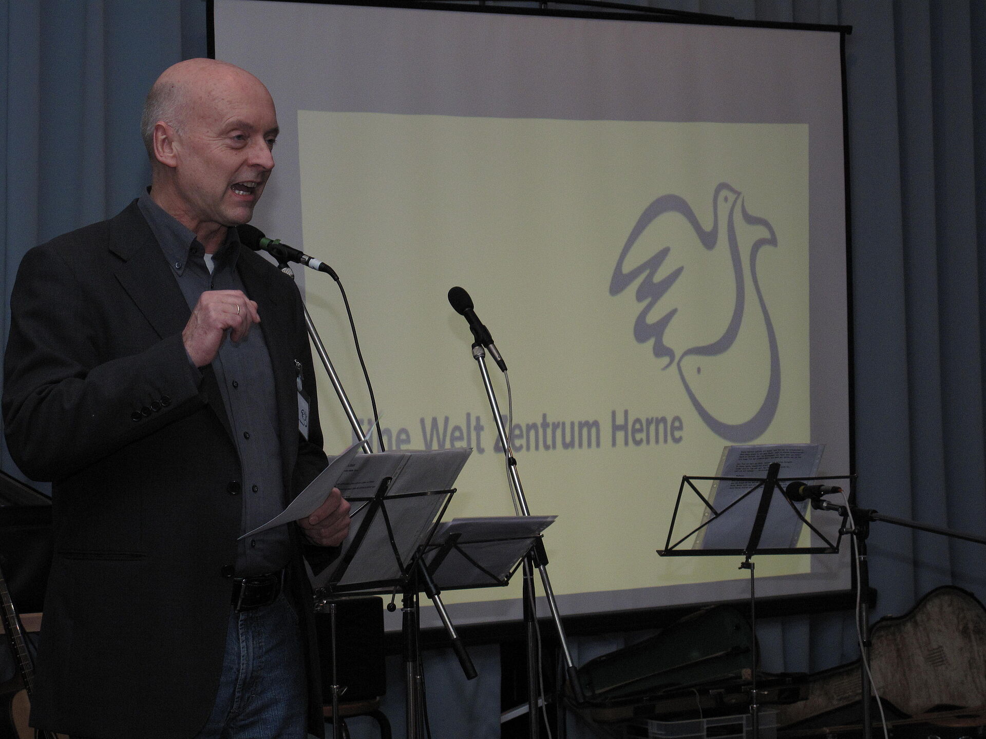 Person auf einer Bühne vor einem Banner mit der Aufschrift 