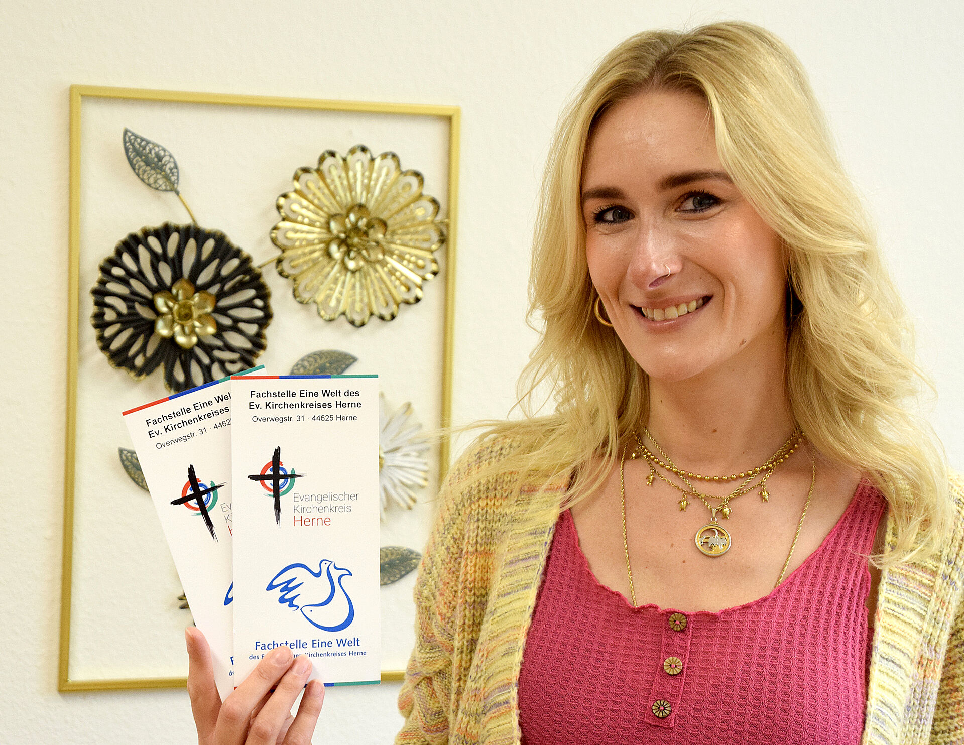 Nina Bauer hält Flyer der Fachstelle Eine Welt in der Hand